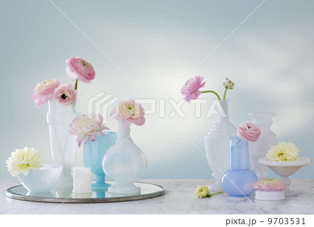 A group of containers, jugs and vases with a variety of pastel coloured delicate flowers. Studio shot. A group of containers, jugs and vases with a variety of pastel coloured delicate flowers. Studio shot. 9703531