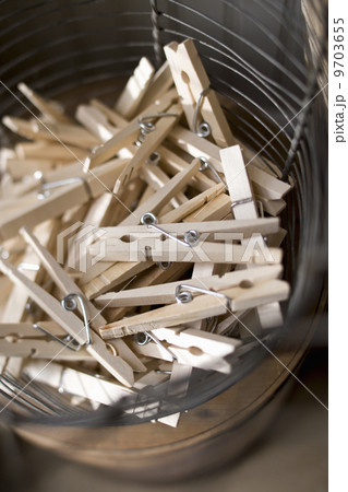 A wire basket with traditional wooden sprung clothespegs or clothespins. 9703655
