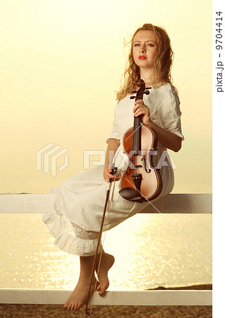 The blonde girl with a violin outdoor 9704414