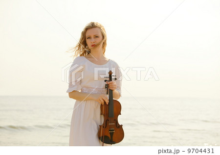 The blonde girl with a violin outdoor The blonde girl with a violin outdoor 9704431
