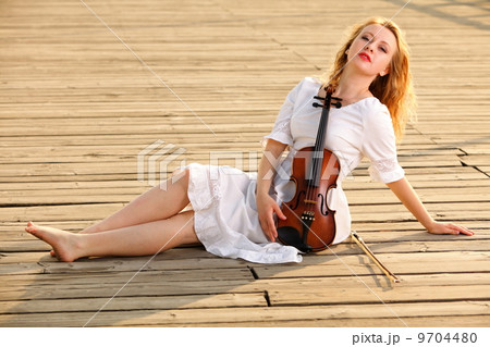 The blonde girl with a violin outdoor The blonde girl with a violin outdoor 9704480