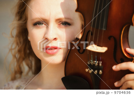 Portrait blonde girl with a violin outdoor 9704636