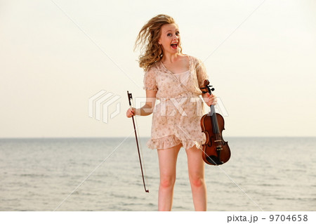 Happy blonde girl with a violin outdoor 9704658