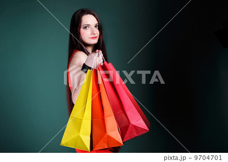 young woman with paper multi coloured shopping bag 9704701
