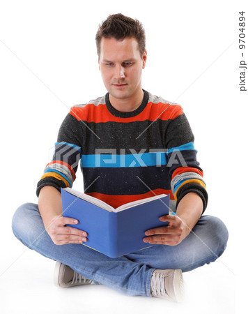 young man reading a book on the floor isolated young man reading a book on the floor isolated 9704894