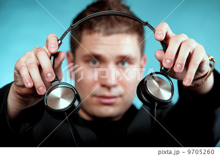 music and technology, smiling man offering headphones 9705260