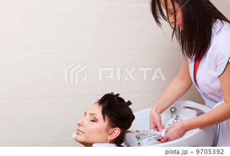 Hairstylist washing woman hair. Hairdressing beauty salon 9705392