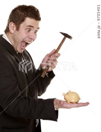 Happy business man breaking piggy bank with hammer 9705401