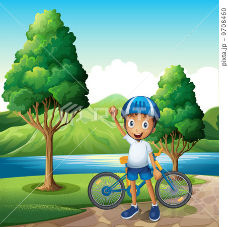 A smiling young boy at the riverbank with his bike 9708460