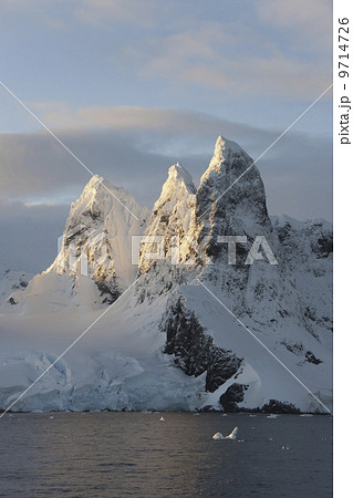 Sunrise on the mountain tops at the north entrance to the Lemaire Channel along the Antarctic Peninsula. 9714726