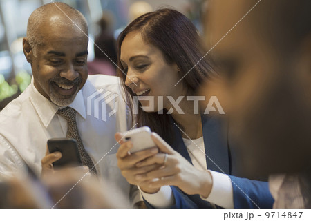 City life. A group of people sitting in a coffee shop, using mobile phones, and talking to each other.  9714847