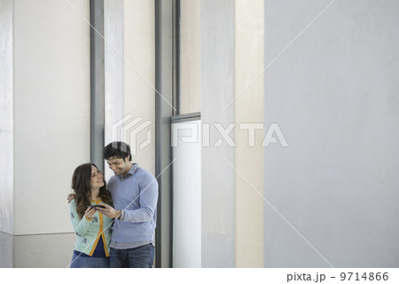 Urban Lifestyle. A young couple, man and woman side by side, looking at a mobile phone.  9714866