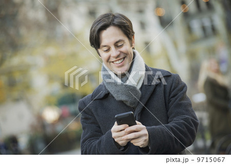 Man in urban park with smartphone 9715067