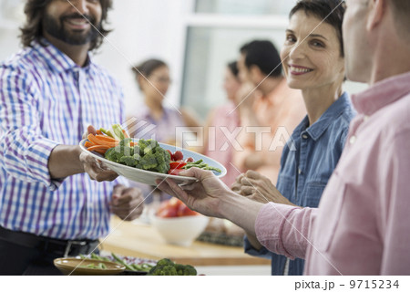 An open plan office in New York City. A working lunch, a salad buffet. A group of men and women of mixed ages and ethnicities meeting together. An open plan office in New York City. A working lunch, a salad buffet. A group of men and women of mixed ages and ethnicities meeting together. 9715234