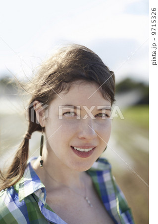 A young woman with braids wearing a green and blue plaid shirt. A young woman with braids wearing a green and blue plaid shirt. 9715326