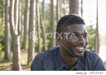 A man in a blue shirt, in the shade of the trees. A man in a blue shirt, in the shade of the trees. 9715327