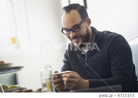 One person sitting at a table in a coffeeshop. A bearded man having a drink of coffee. 9715353