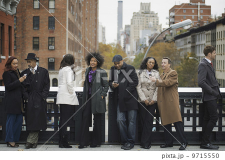 City life. A group of people on the go, keeping in contact, using mobile phones, and talking to each other. Standing in a line. City life. A group of people on the go, keeping in contact, using mobile phones, and talking to each other. Standing in a line. 9715550