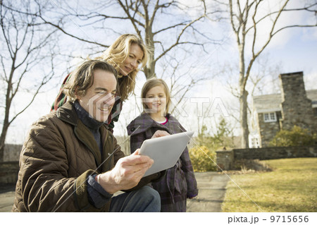 An Organic Farm in Winter in Cold Spring, New York State. A man holding a digital tablet in his hands. A woman and a child. An Organic Farm in Winter in Cold Spring, New York State. A man holding a digital tablet in his hands. A woman and a child. 9715656