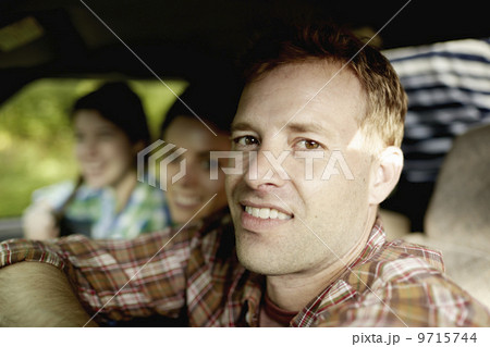 Three passengers in the cab of a pickup truck. One young man driving. Two young women sitting beside him. Three passengers in the cab of a pickup truck. One young man driving. Two young women sitting beside him. 9715744