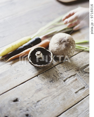 A domestic kitchen table with a worn scrubbed surface. A bunch of carrots, and mushrooms. Fresh vegetables. A domestic kitchen table with a worn scrubbed surface. A bunch of carrots, and mushrooms. Fresh vegetables. 9716016