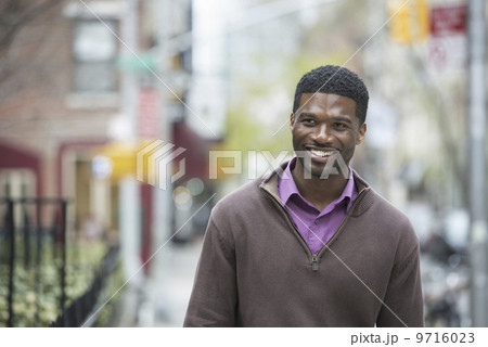 Outdoors in the city in spring. An urban lifestyle. A young man checking his phone and texting. Cycle rack and stored bicycles. Outdoors in the city in spring. An urban lifestyle. A young man checking his phone and texting. Cycle rack and stored bicycles. 9716023