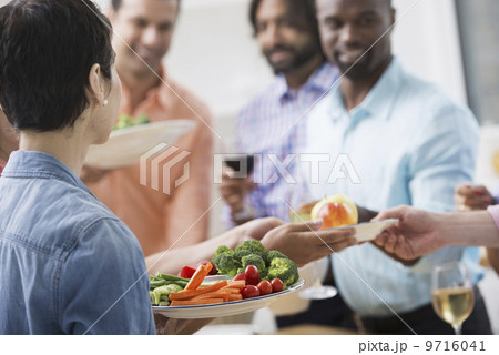 An open plan office in New York City. A working lunch, a salad buffet. A group of men and women of mixed ages and ethnicities meeting together. An open plan office in New York City. A working lunch, a salad buffet. A group of men and women of mixed ages and ethnicities meeting together. 9716041