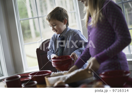 A family home. Two children laying the table with crockery for a meal.  9716314