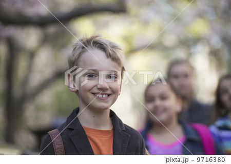 Outdoors in the city in spring. An urban lifestyle. Two children side by side, with book bags.  9716380