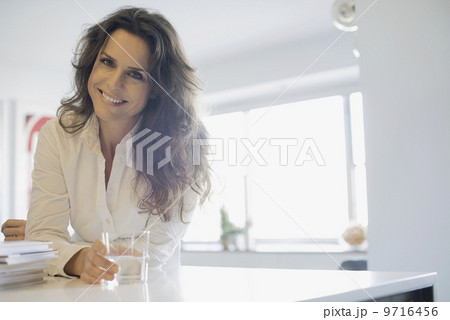 Woman at home in kitchen with glass of water 9716456