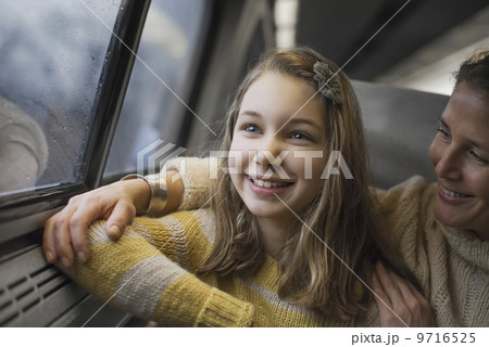A man and a young girl sitting beside the window in a train carriage looking out at the countryside. Smiling in excitement. 9716525