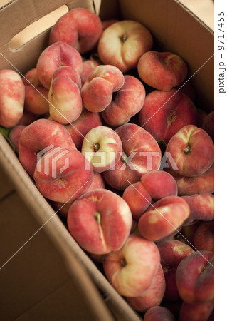 Fresh fruit on an organic farmstand. Doughnut peaches in a box. 9717455
