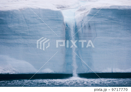 A waterfall is created by a melting iceberg, Svalbard, Norway 9717770