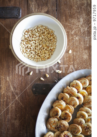 A white pottery bowl, full of dried corn kernels. A dish of baked pastries. 9717959