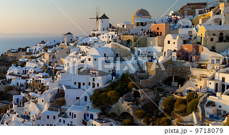 The windmills of Santorini in Greece. A hilltop town of whitewashed houses. Sunset. 9718079