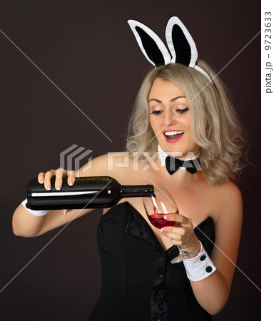 Playful girl at the party pours wine 9723633