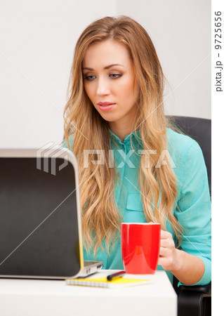 Young blond woman working with a laptop 9725656