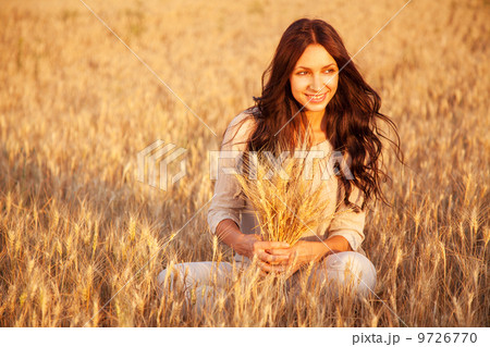 Beautiful brunette lady in wheat field at sunset 9726770