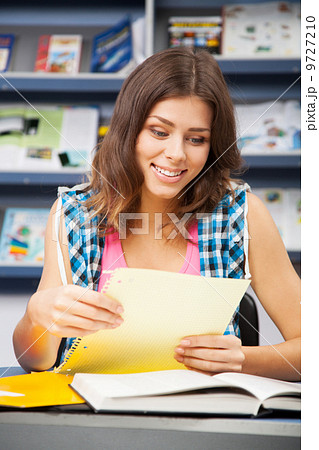 Beautiful female student in a library 9727210