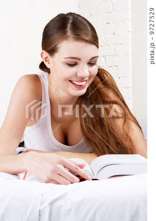 Lovely woman reading a book in bed Lovely woman reading a book in bed 9727529