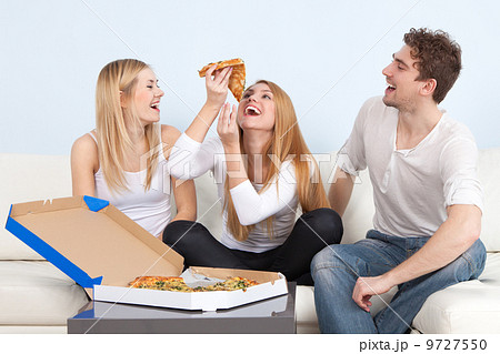 Group of young people eating pizza at home 9727550