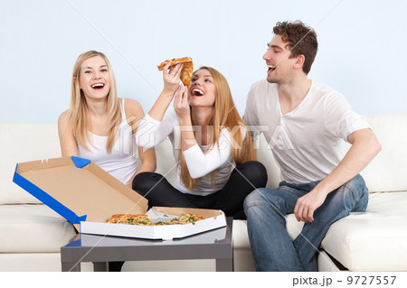 Group of young people eating pizza at home 9727557
