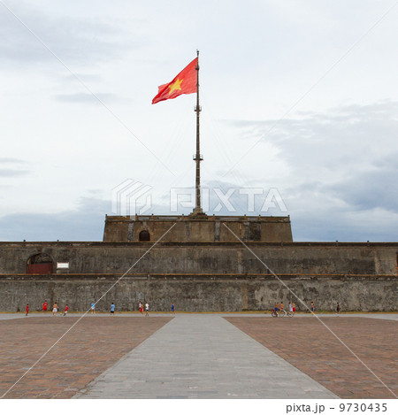 HUE, VIETNAM - AUG 4: Boys playing football in front of the Flag 9730435