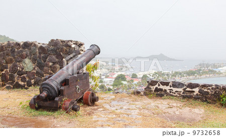 Very old rusted canon pointing at a bay 9732658
