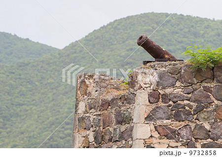 Very old rusted canon on top of an old wall 9732858