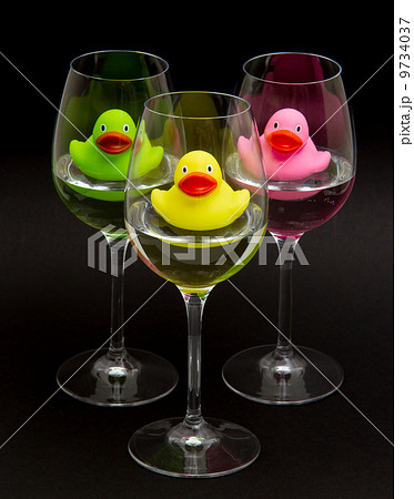 Green, yellow and pink rubber ducks in wineglasses Green, yellow and pink rubber ducks in wineglasses 9734037
