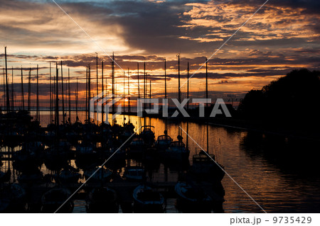 Sailboats and yachts in harbor with sunset 9735429
