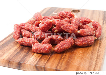 A heap of mini Salamis on wooden board 9736168