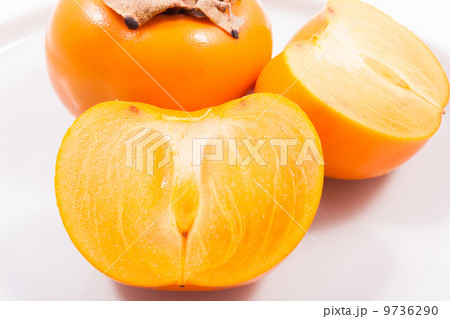 Fresh persimmons on plate isolated on white Fresh persimmons on plate isolated on white 9736290
