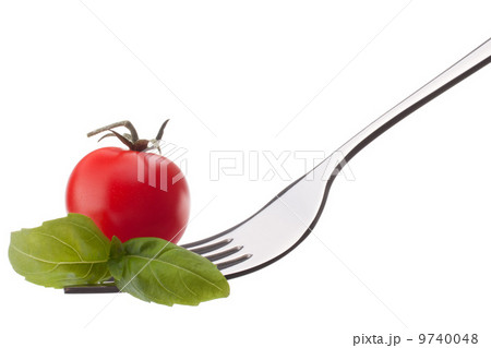 Basil leaf and cherry tomato on fork isolated on white backgrou Basil leaf and cherry tomato on fork isolated on white backgrou 9740048